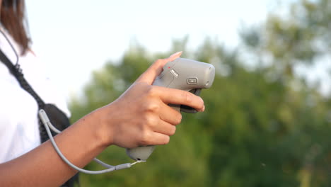 close up of female hand holding remote motion controller of fpv drone