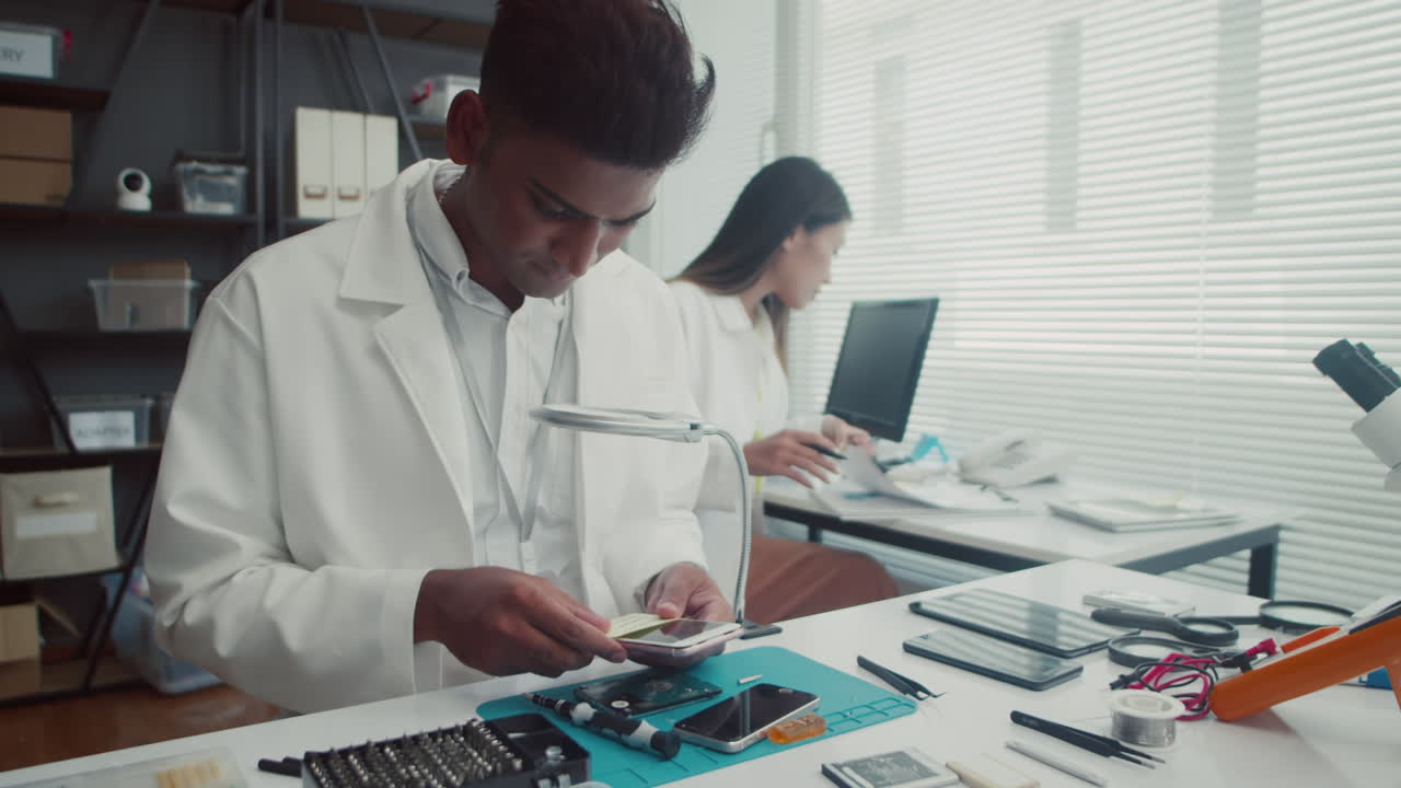 Couple of Repair Center Specialists Working on Devices