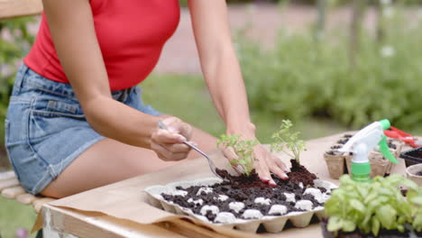 woman in red top sitting in garden, looking thoughtful in garden setting