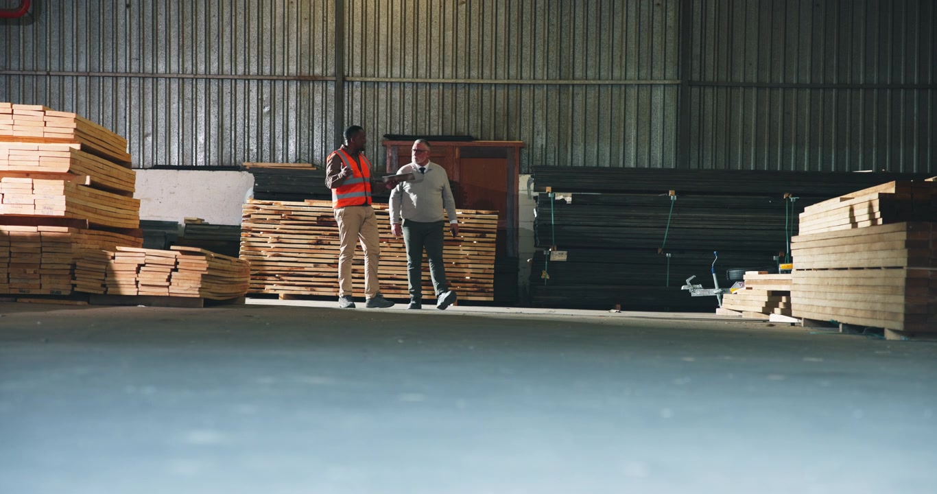 Warehouse Manager and Worker Discussing Inventory in Lumber Yard
