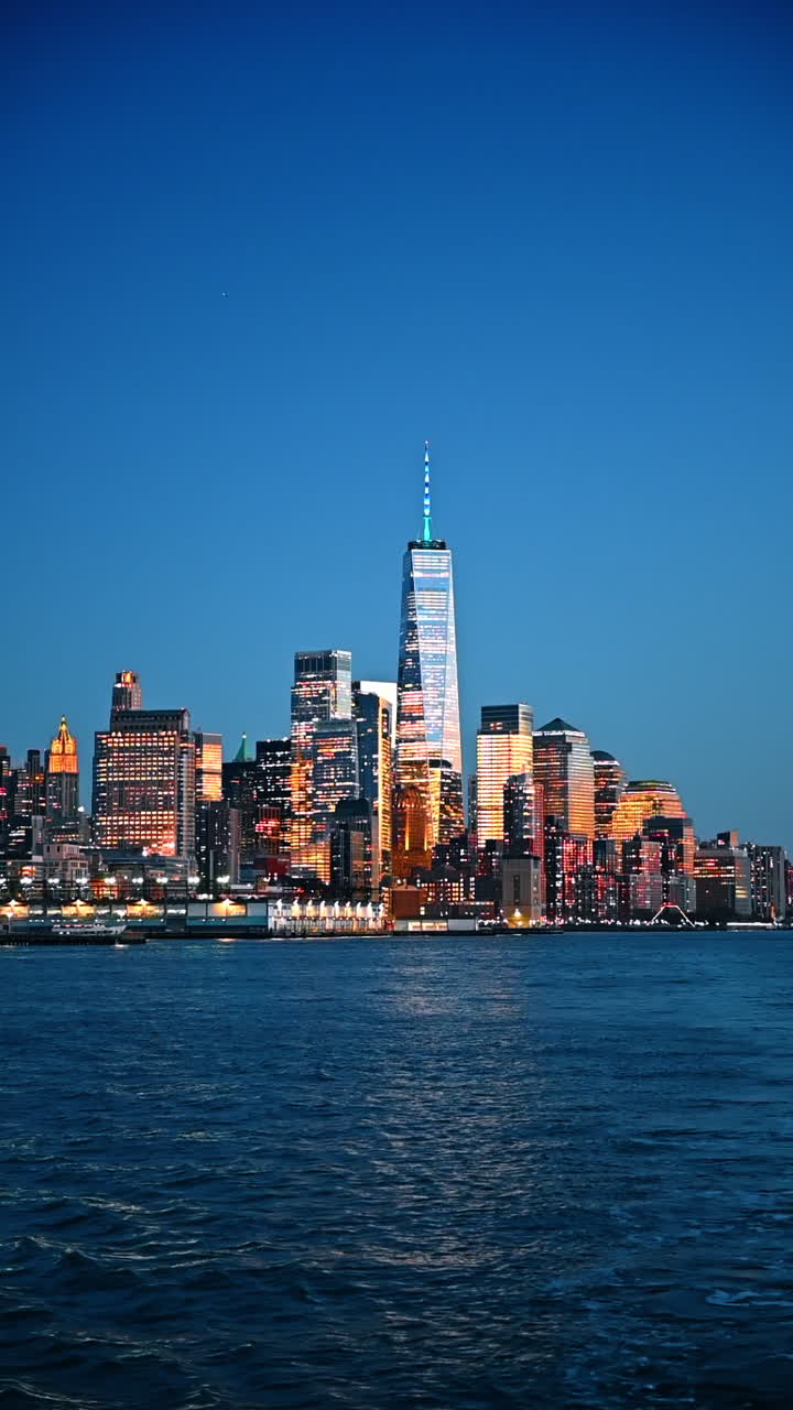 Splendido skyline di Manhattan illuminato dal sole al tramonto. Vista su New York durante l'ora d'oro dal paesaggio fluviale. Video verticale