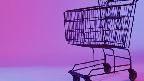 video of shopping trolley with copy space over neon purple background