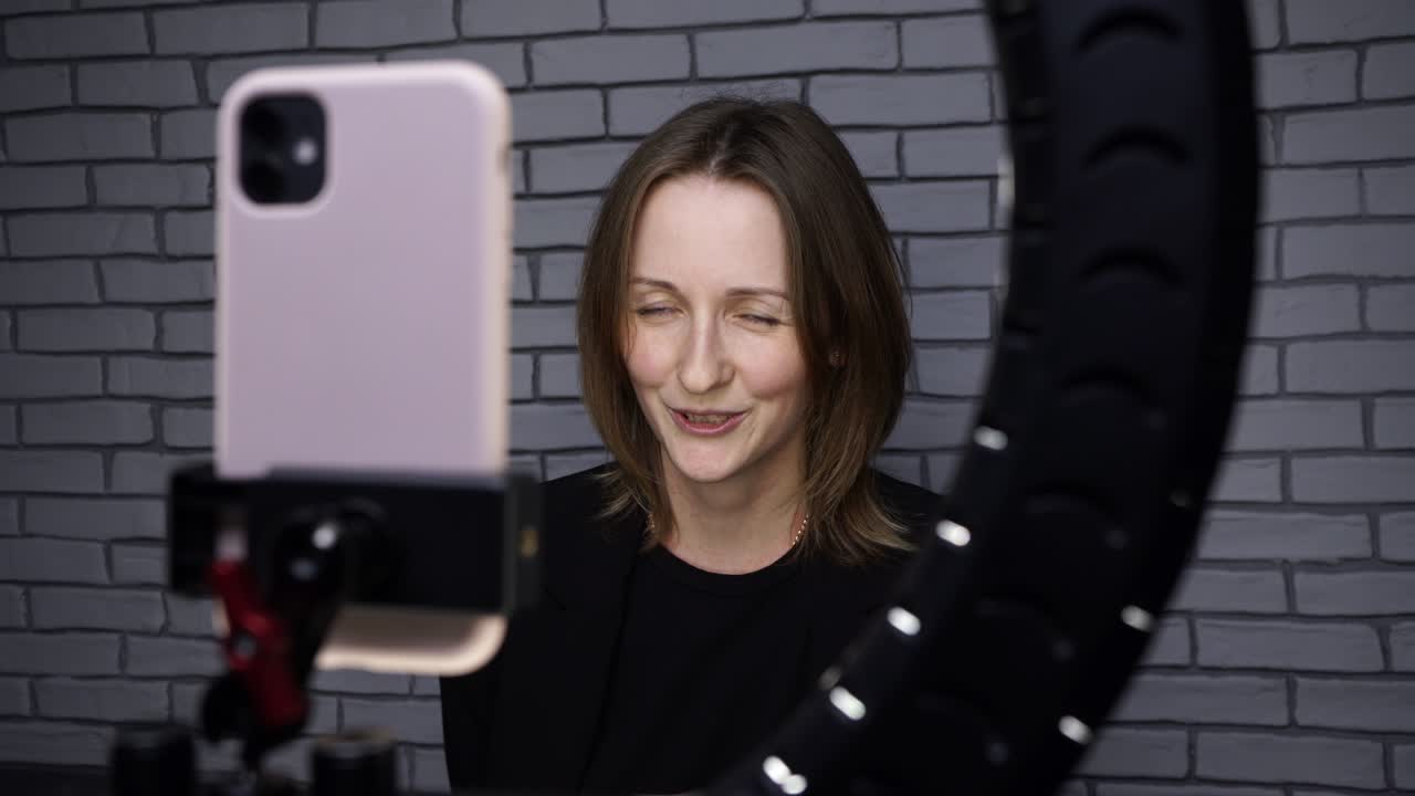 imágenes de una blogger disparando una historia con una lámpara de anillo en el fondo de una pared de ladrillo