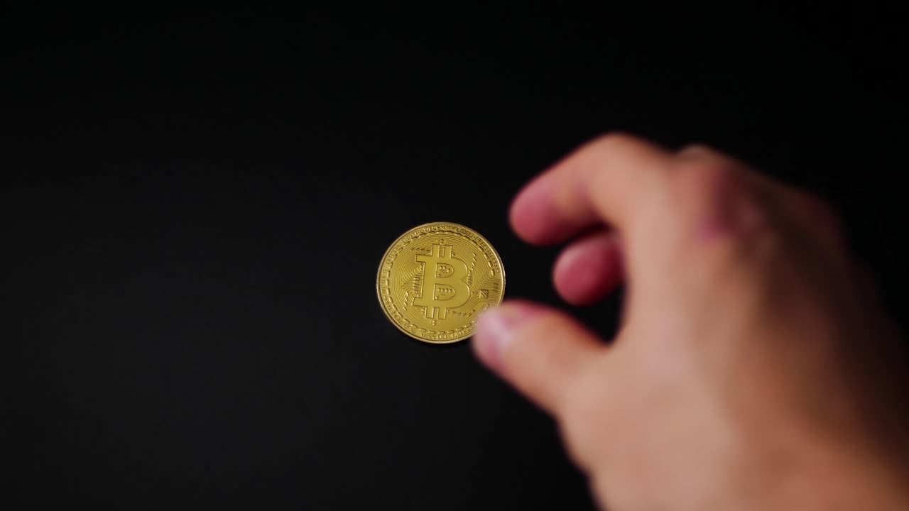 mano entrando en tiro para recoger un bitcoin