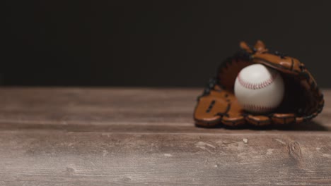 cerca de estudio de béisbol todavía la vida con la pelota en receptores guante en el piso de madera 1