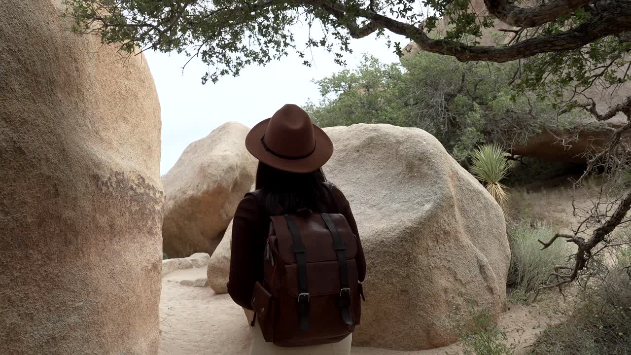 Woman Hiking Through Rocky Desert Landscape with Backpack