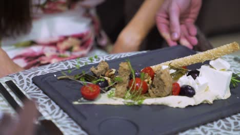 Un-Hombre-Sirviendo-Nueva-Cocina-Mediterránea-A-Una-Mujer.