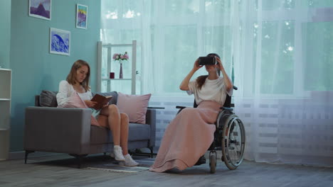 Woman-reads-book-while-disabled-friend-in-VR-glasses-plays