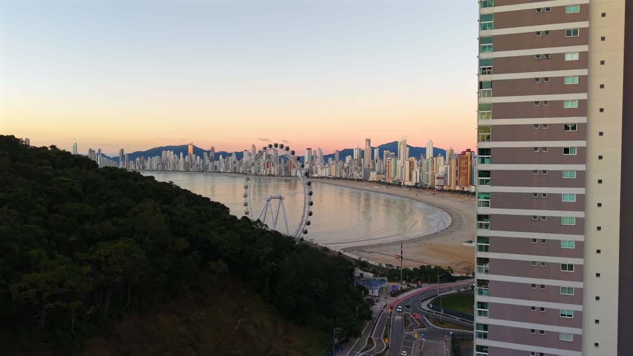 Slow pan at sunrise around a tower showing Balneario Camboriu’s coast and skyscrapers
