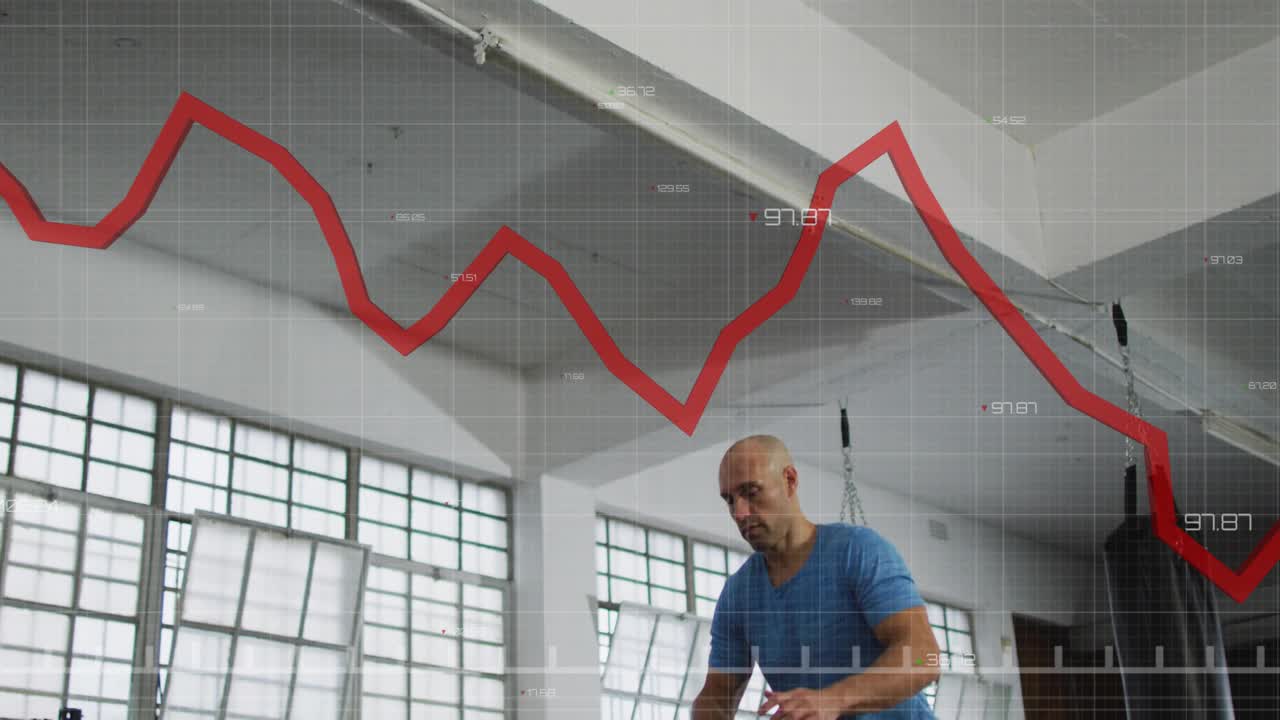 Uomo in palestra accovacciato che slancia le braccia, salta sul plyo box, si allena mentre un grafico rosso traccia il movimento