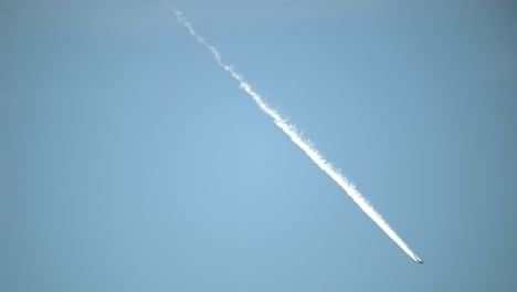 contrails of commercial aircraft against a background of blue sky