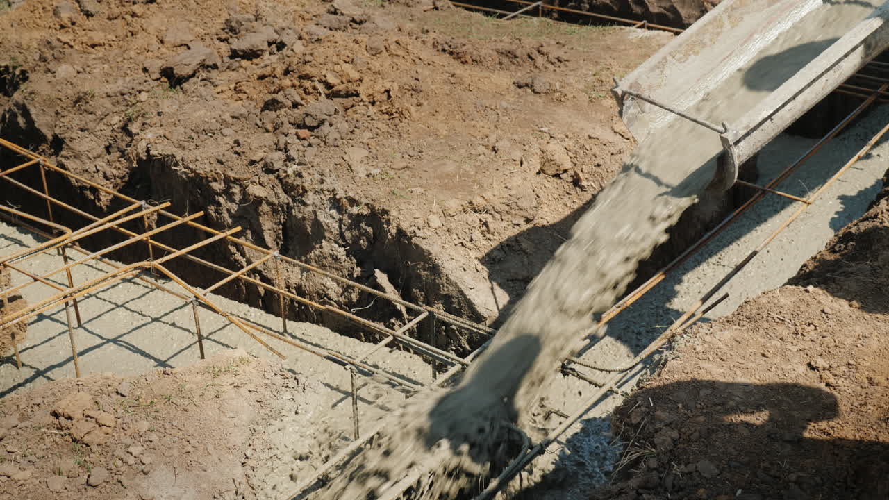 el hormigón fluye a través de la tubería hacia los cimientos del concepto de construcción de cabañas en el sótano