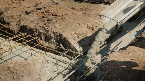 concrete flows through the pipe into the foundation of the basement construction of cottages concept