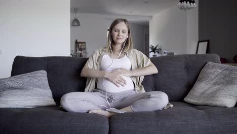 Front-view-of-expectant-mother-resting-on-sofa-at-home