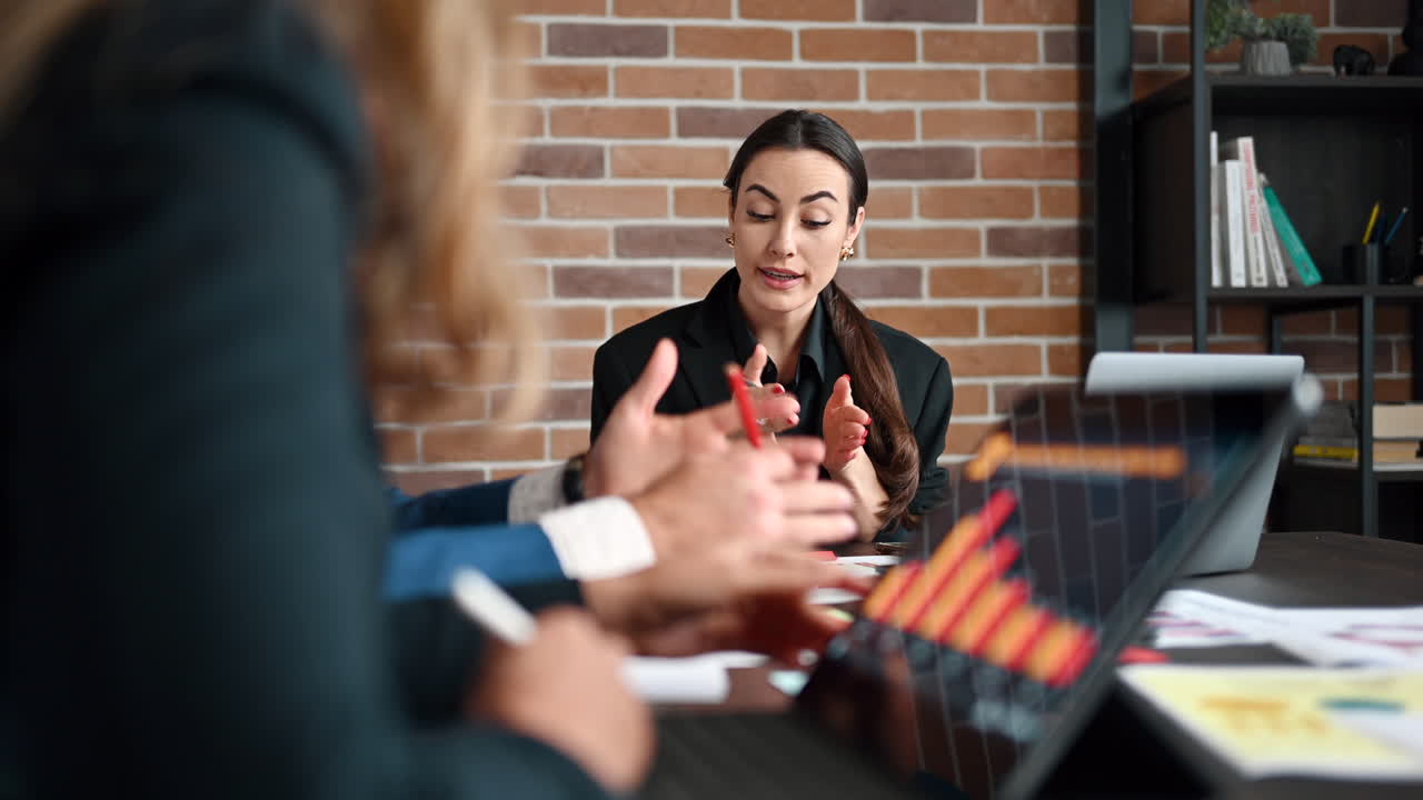 Coworkers talking at a table in an office