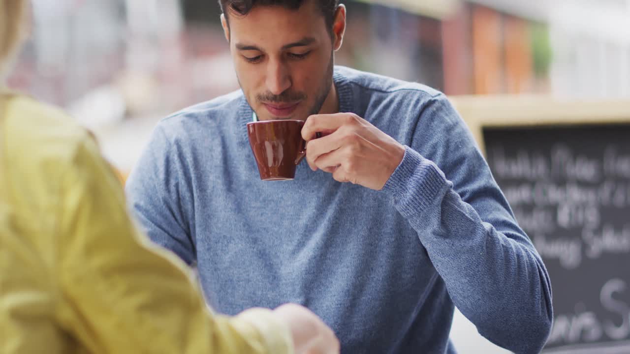 vista frontal de un hombre caucásico bebiendo café en una terraza