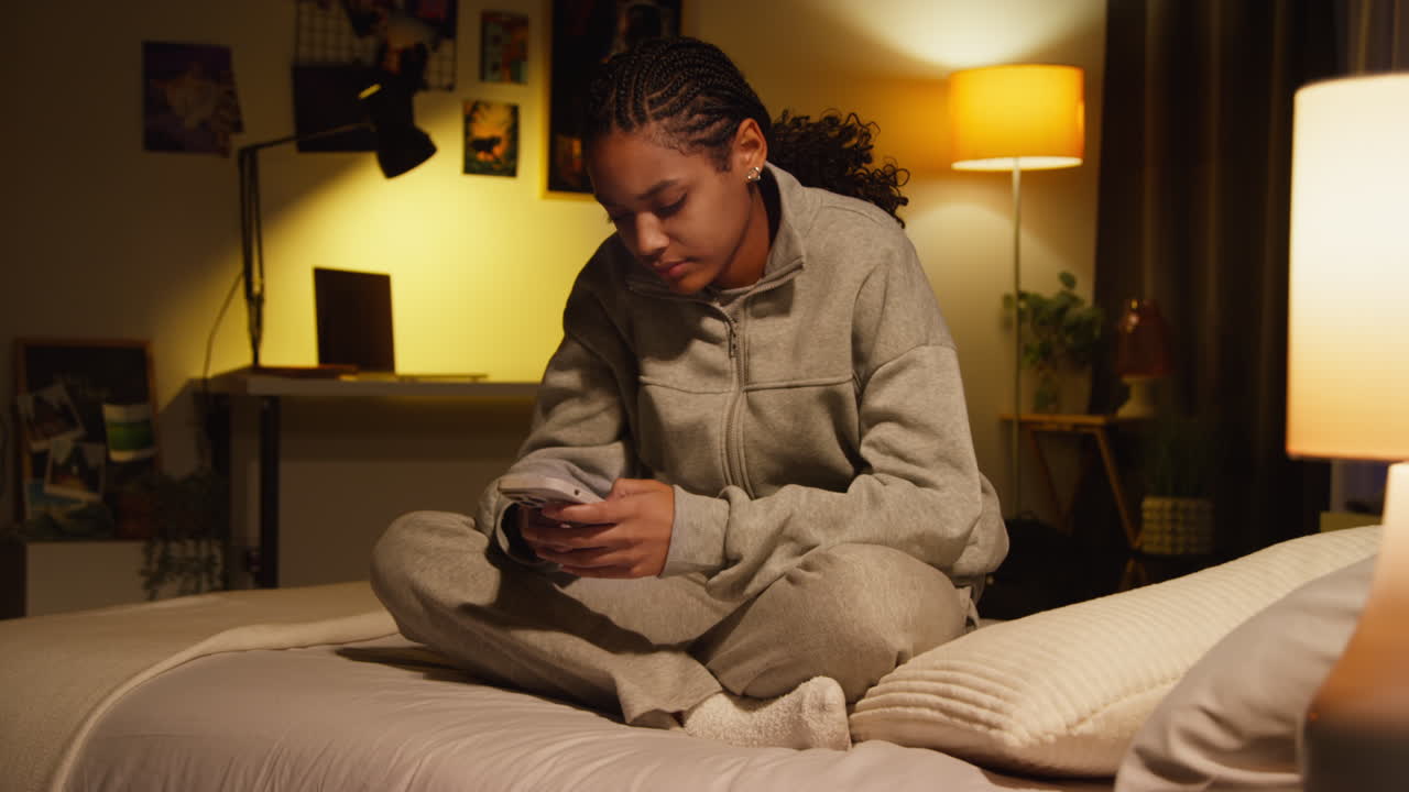 Teenage Girl Using Phone in Bedroom at Night