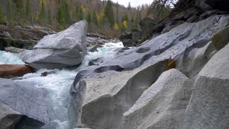 Wide-view-of-a-magical-creek-with-interesting-stones-and-turquoise-water,-marble-castle,-Norway