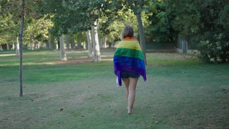 woman walking in park with pride flag
