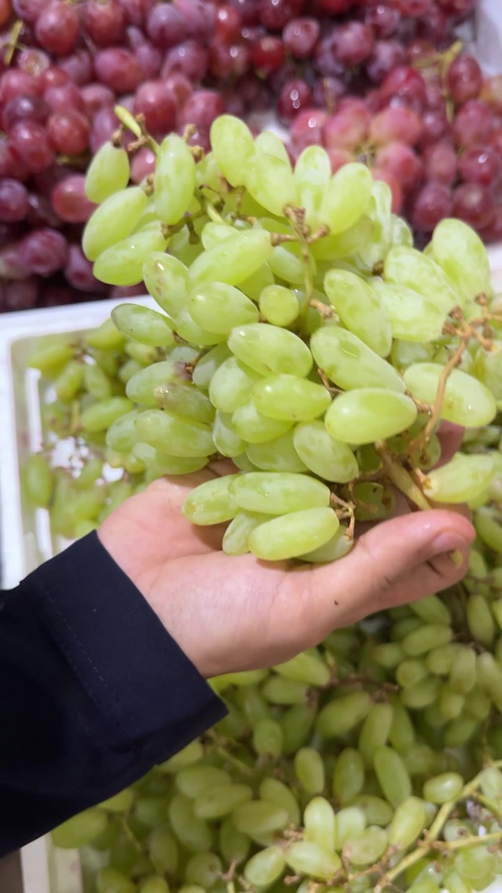 Mão Colhendo Uvas Verdes Frescas em um Mercado