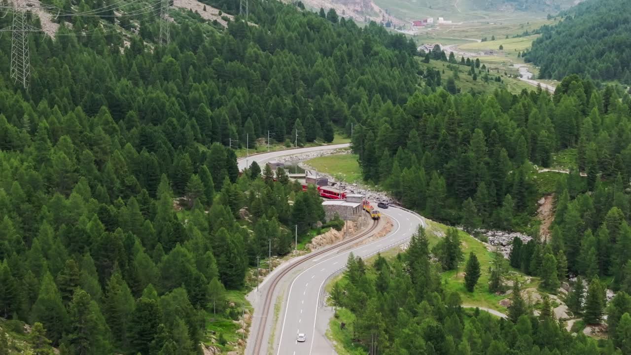 Explore Swiss Alps from above, with train journey alongside winding roads - 4K