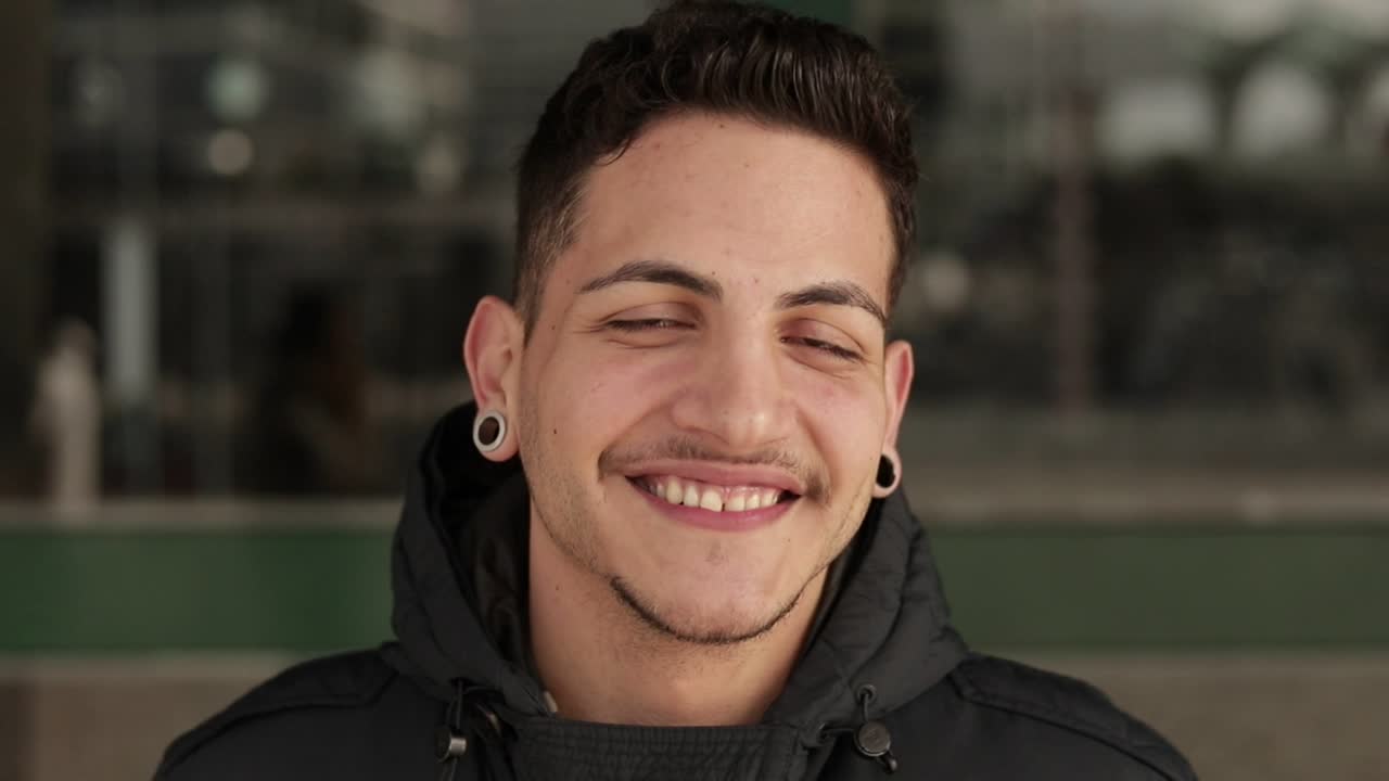 joven guapo y feliz con ropa cálida mirando a la cámara