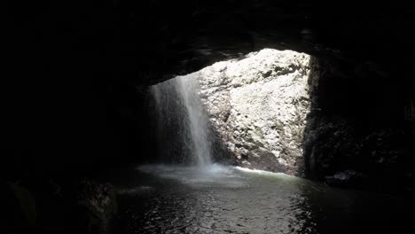 Cascadas-De-Agua-A-Través-Del-Techo-De-Una-Cueva-Submarina-Del-Bosque-De-La-Era-Jurásica-Iluminada-Por-Rayos-De-Luz-Solar