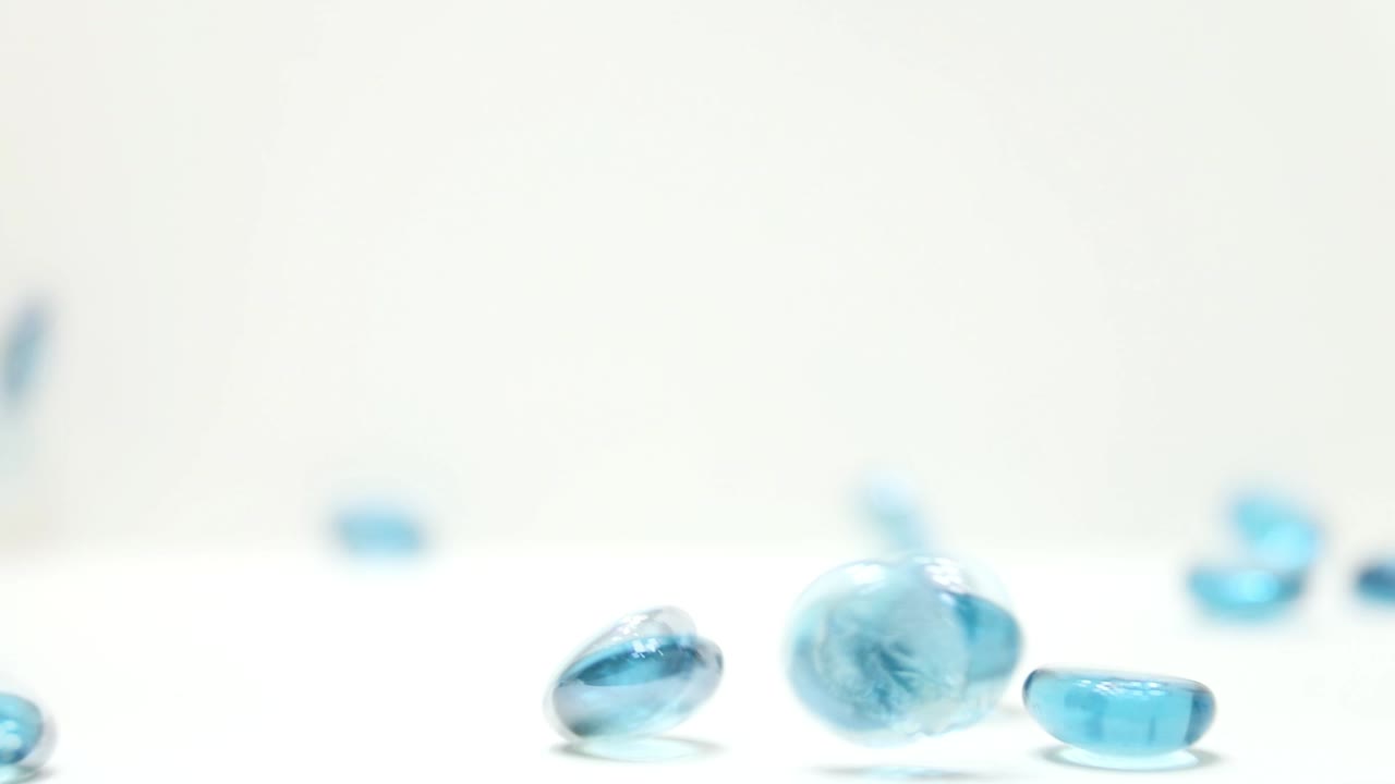 Forward Slow Motion of Blue Glass Disks bouncing and tumbling into frame
