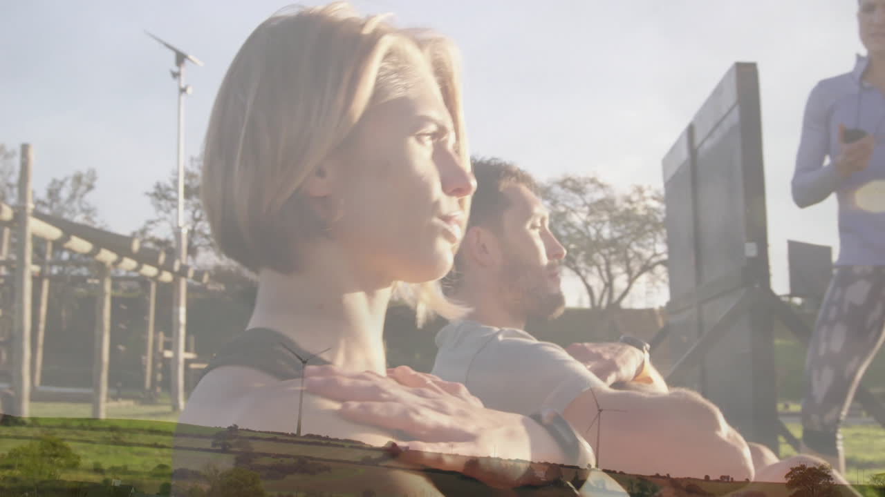 Relaxing outdoors, two people with wind turbines and landscape in background