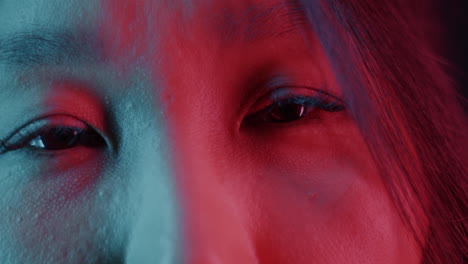Close-up portrait of a woman with neon red and blue lighting