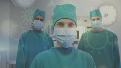 Multiple-covid-19-concept-icons-against-group-of-male-and-female-surgeons-wearing-surgical-masks