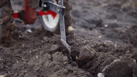 Vista-De-Cerca-De-Un-Cultivador-Que-Prepara-El-Suelo-Del-Jardín,-Nueva-Temporada-De-Siembra-En-Una-Granja-De-Vegetales-Orgánicos-Caseros.-Filmado-En-Cámara-Lenta