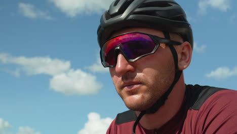 close-up of the face of a cyclist dressed in a bicycle helmet and protective sports glasses