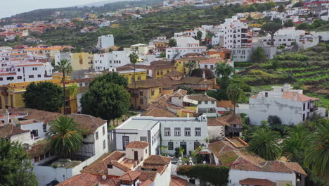 Vista-De-Un-Pueblo-Típico-Español,-Icod-De-Los-Vinos,-En-La-Isla-De-Tenerife,-España,-Con-Lujosas-Mansiones-Y-Villas,-Parques-Y-Jardines,-Palmeras-Exóticas-Y-Tejados-Rojos,-Toma-Aérea-De-Pedestal-4k