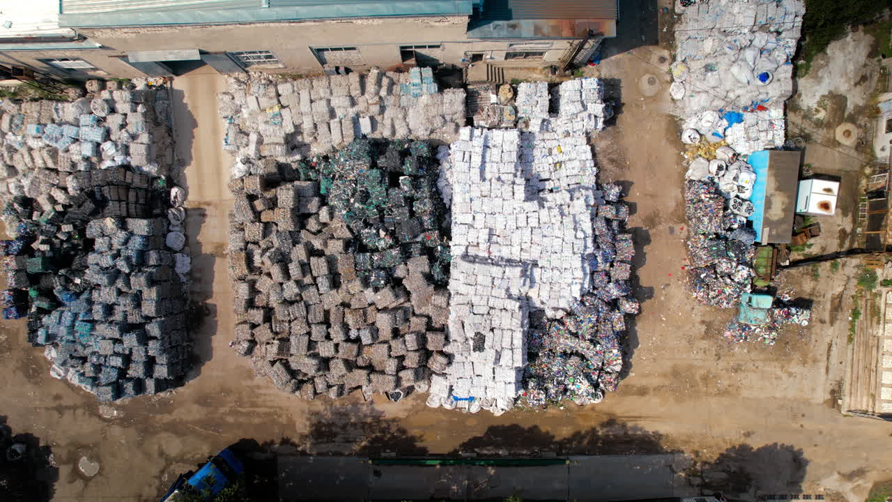 Multiple cubes of compressed garbage near the waste recycling factory in open air