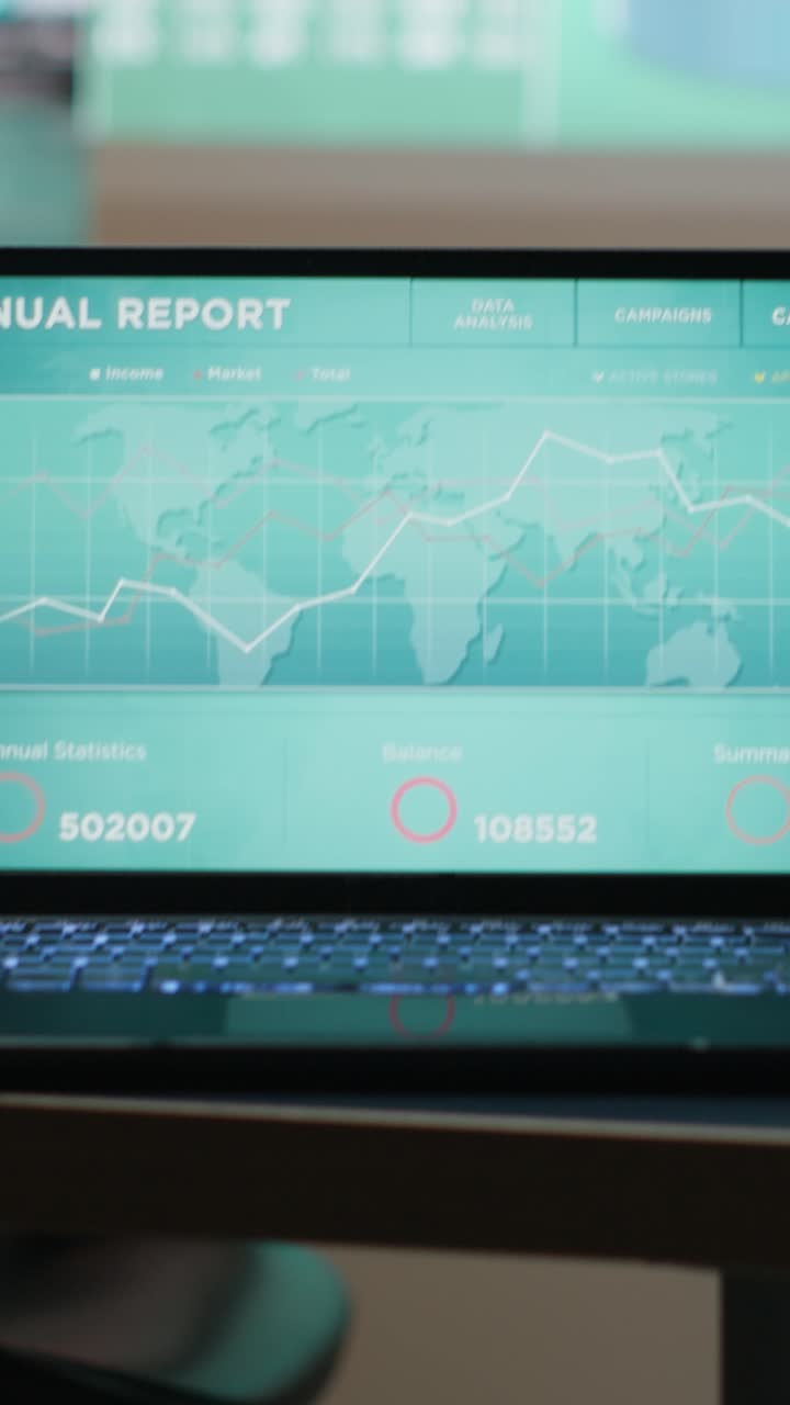 Vertical Video Close up of laptop running data insights in empty dark office late at night
