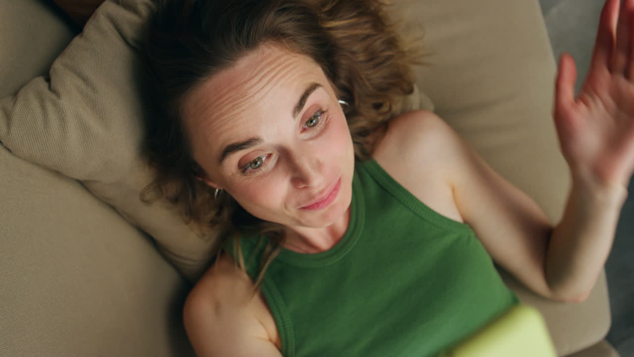 mujer sonriente llamando por teléfono colocando el sofá en primer plano. chica feliz hablando