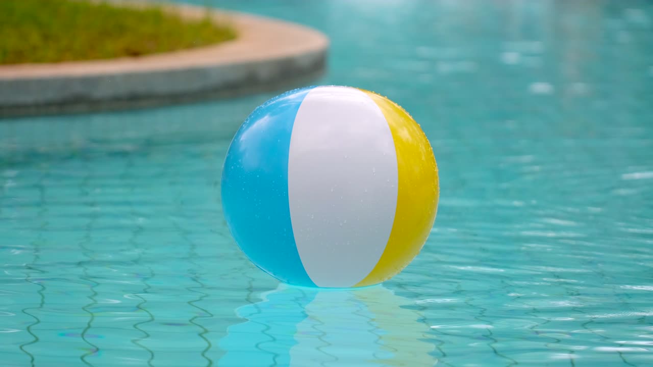 Colorful inflatable beach ball floating in swimming pool