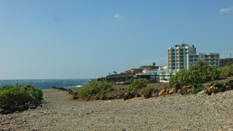 Teneriffa-Strandstraße-Mit-Hotel-Und-Wellen-Im-Hintergrund-Und-Steinweg,-Straße