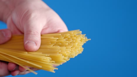 male hands holding spaghetti pasta dry.