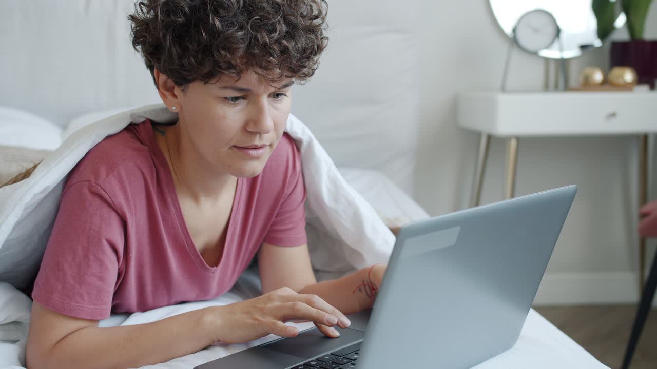 mujer trabajando en la computadora portátil en la cama