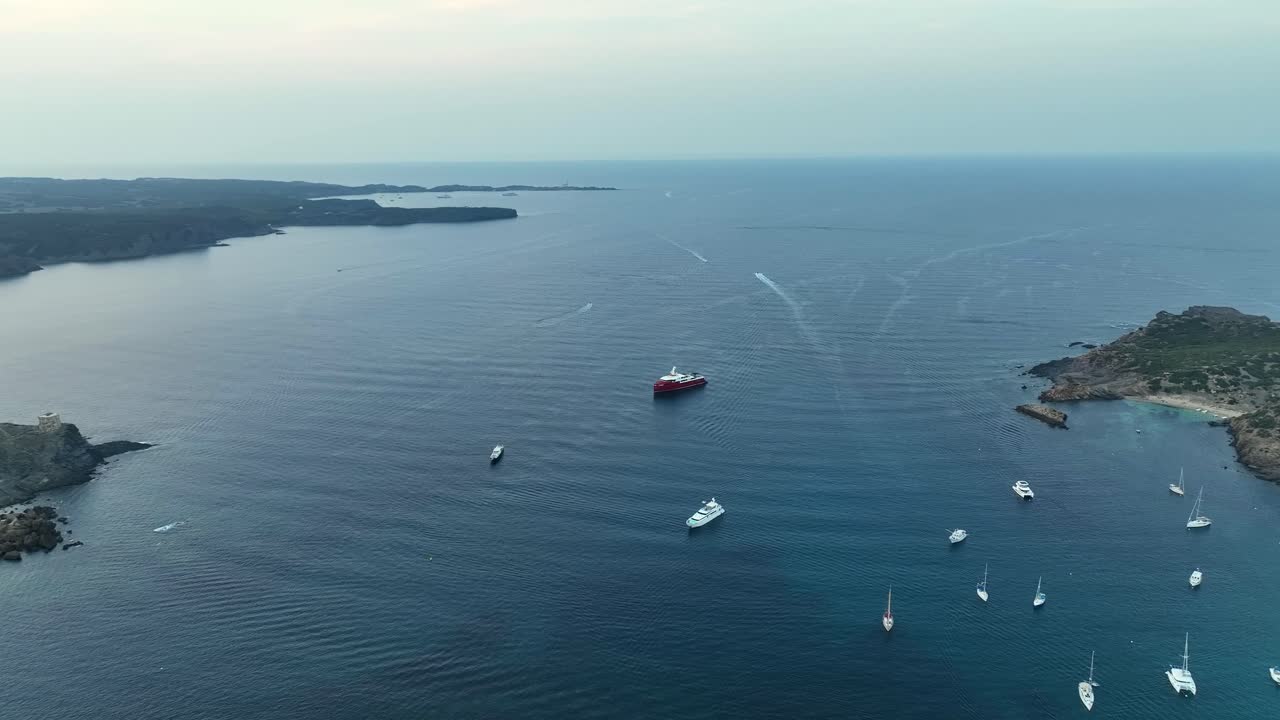 Drone shot of a vessel anchored in the water with land on both sides.