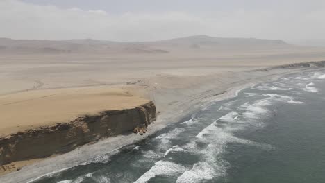 tall sand cliffs in coastal peru where desert meets pacific ocean