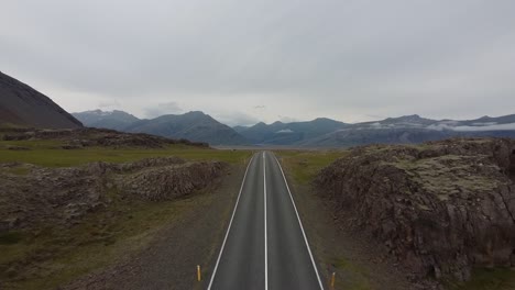 Empty-two-lane-road-ahead-in-Iceland,-aerial-drone-view-forward