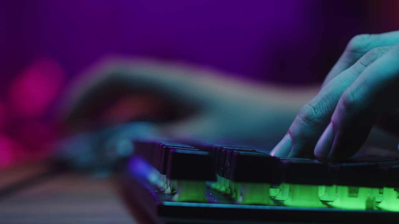 Close-up of Gamer's Hands Using Mouse and Backlit Keyboard