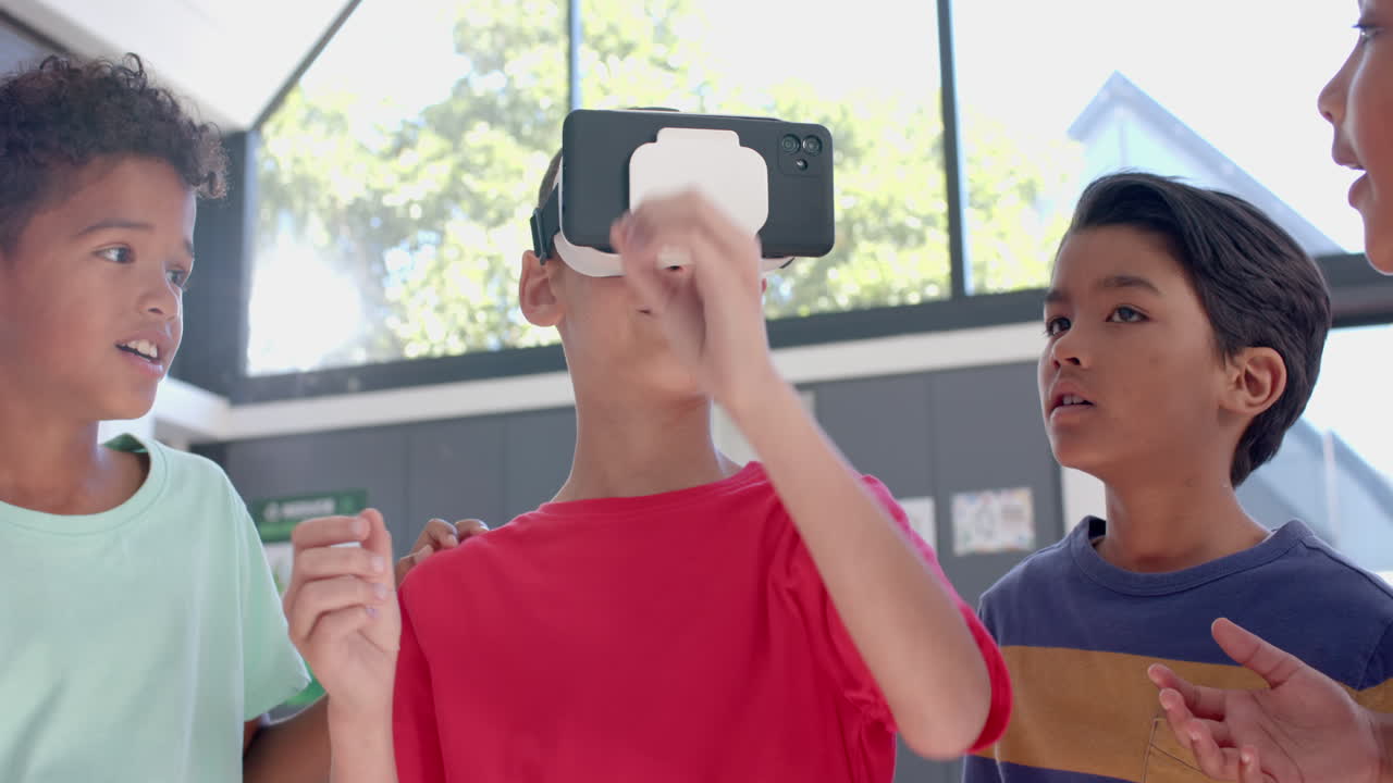 Biracial boys explore virtual reality in a bright room at school in the classroom