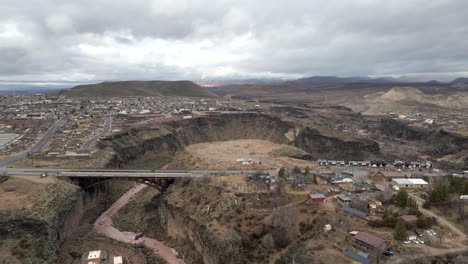 Bridge-over-the-Virgin-River-in-La-Verkin,-Utah-with-a-panning-aerial-reveal-of-the-city