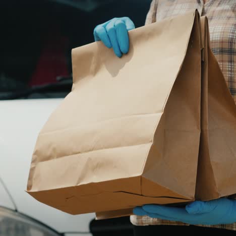 El-Mensajero-Transfiere-Bolsas-De-Comestibles-Al-Destinatario-Cerca-De-La-Camioneta-De-Servicio-De-Entrega.