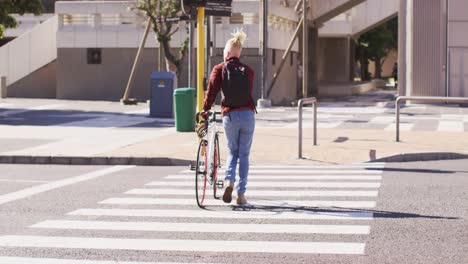Albino-african-american-man-with-dreadlocks-crossing-road-with-bike