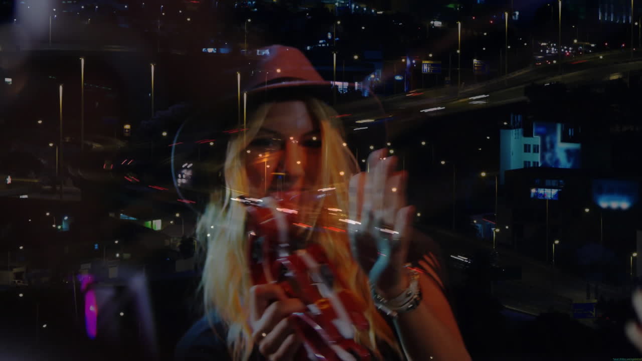 woman singing into microphone holding tambourine indoors, overlaying city lights for music tech